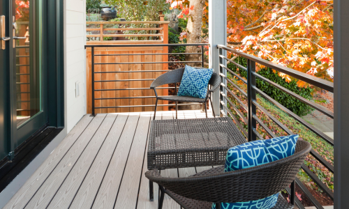An outdoor deck with brown boards and black railings.
