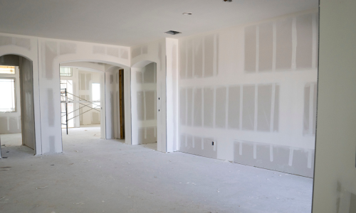 The interior of a home, being renovated with drywall and spackled walls.