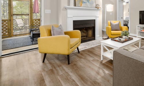 A fully furnished living room with laminate wood flooring.