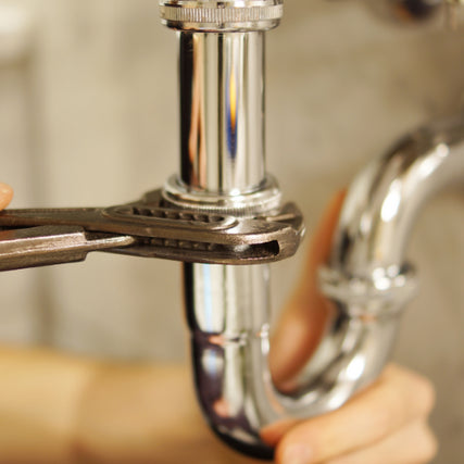 PlumbingA pipe being tightened by a wrench.