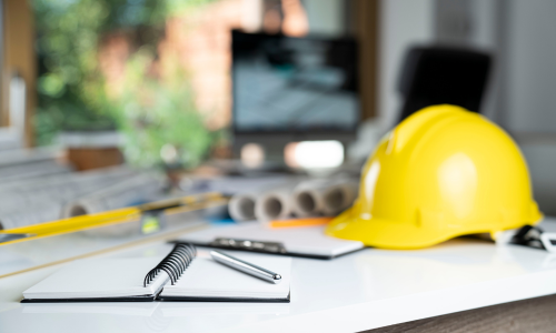 Contractor supplies spread across a table, next to an open notebook and pen.
